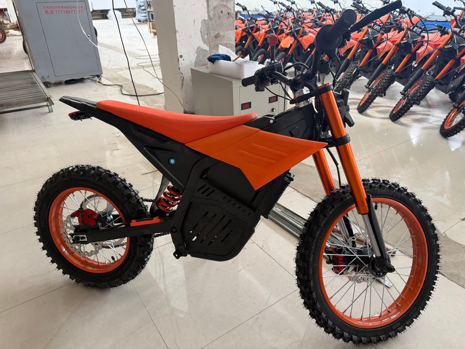 JoltMoto Trail — orange seat and tank, lineup of inventory behind it